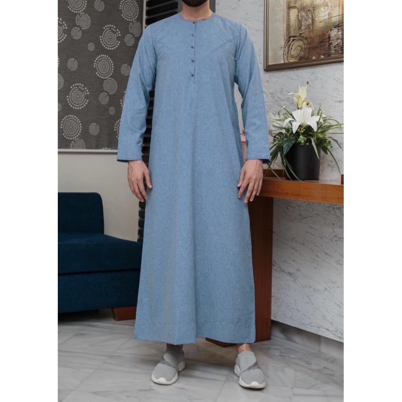 Ontdek deze prachtige Emirati Khamis, vervaardigd uit hoogwaardige en zachte stof die een luxueuze uitstraling heeft. Met zijn elegante ontwerp is deze Khamis voorzien van twee handige zakken en stijlvolle drukknopen, waardoor het de perfecte keuze is voor verschillende gelegenheden, zoals dagelijkse moskeebezoeken of als comfortabele kleding thuis.